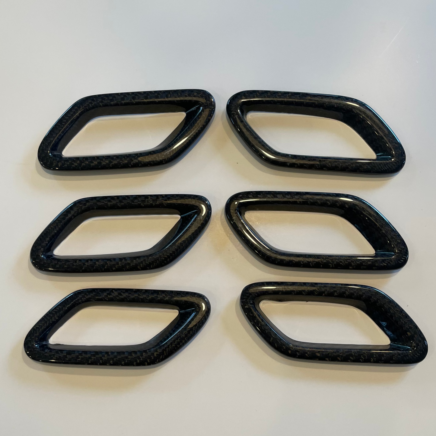 Six black rectangular plastic parts on a white background