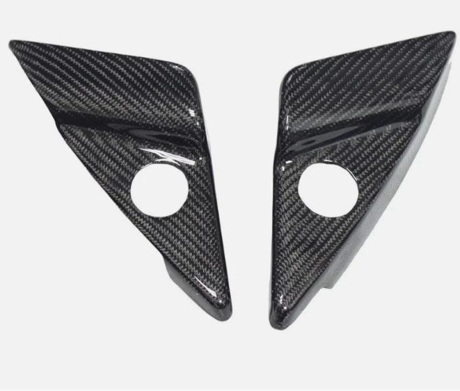 Two carbon fiber triangle-shaped car parts on a white background