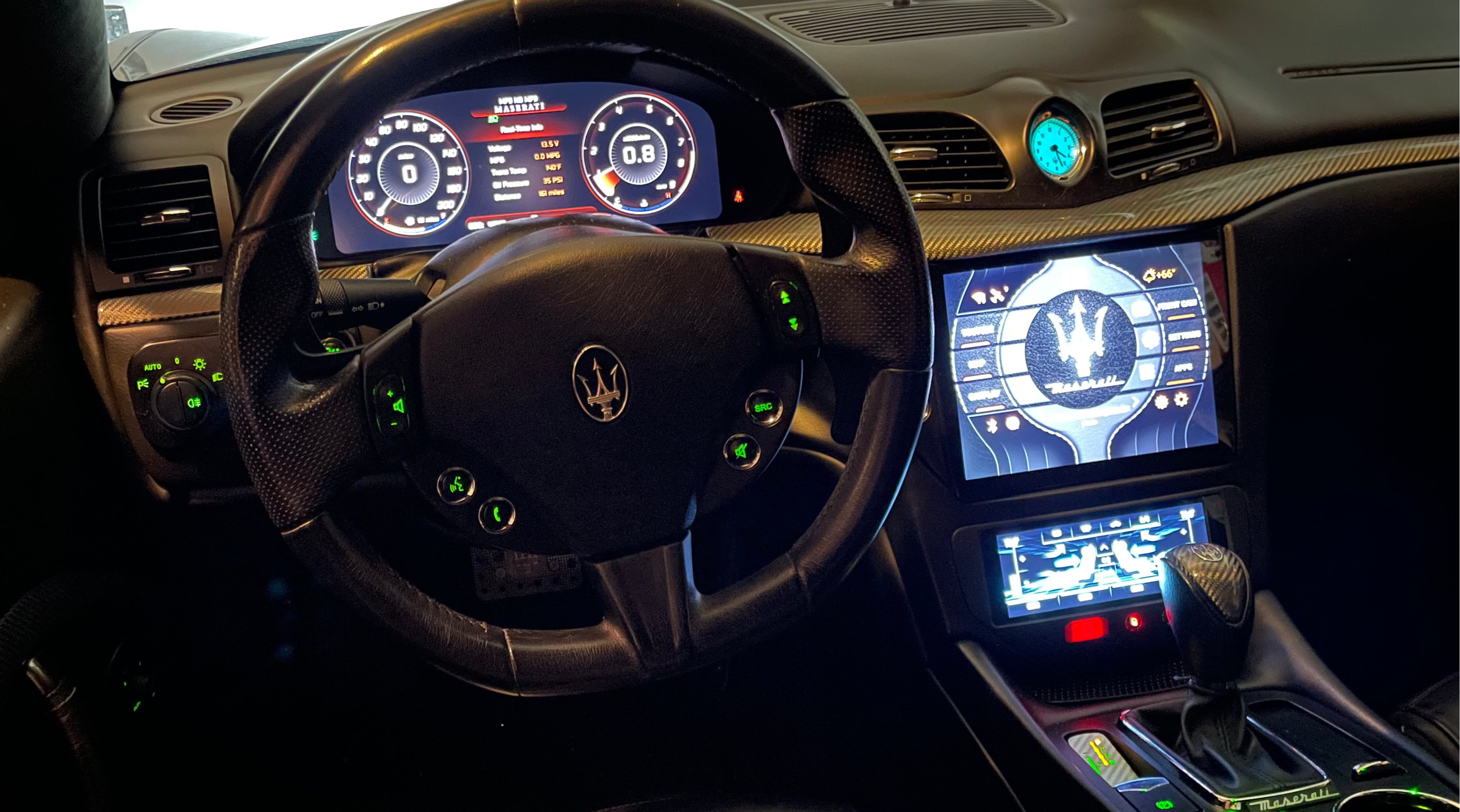 Car interior with steering wheel and dashboard displaying Maserati logo