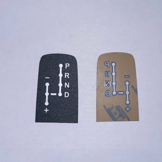 Two gear shift covers, one black and one beige, on a white background.