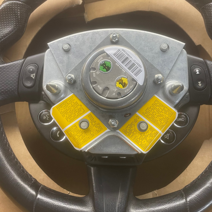Steering wheel with a central hub and buttons on a cardboard background