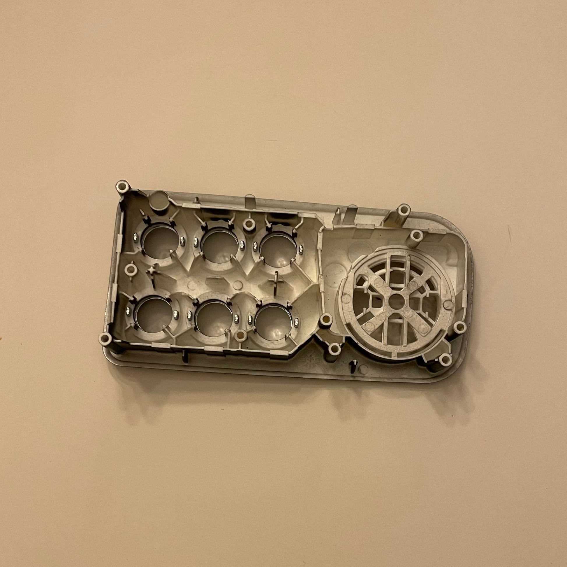 Metal engine block on a beige background
