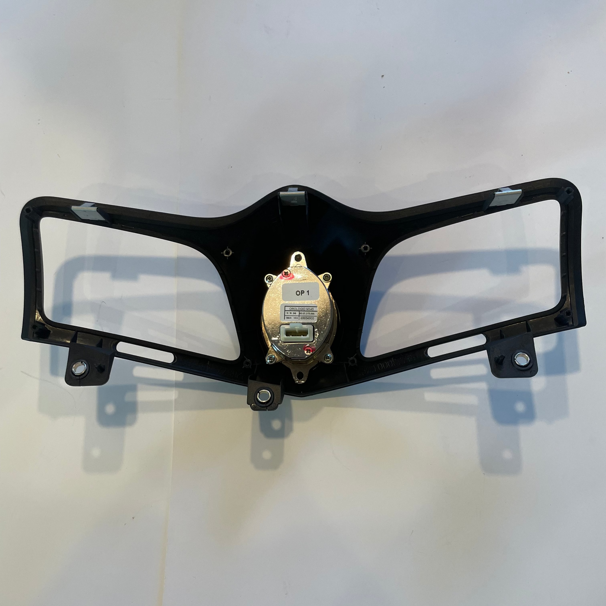 Black AC vent frame with a central electronic component on a white background