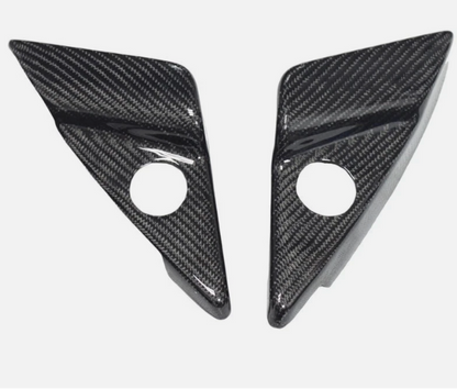 Two carbon fiber triangle-shaped car parts on a white background