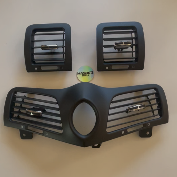 Three car grille components on a beige background with a small round object in the center.